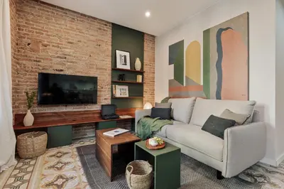a living room with a couch and a tv at Cira - 2 bedrooms and balcony in Vila de Gràcia in Barcelona