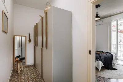 a hallway with white walls and a door with a mirror at Baeza - 2 bedrooms and office in Eixample Esquerra in Barcelona