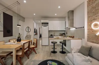 a kitchen with white cabinets and a couch at Chuck - 2 bedrooms and balcony in Sant Antoni in Barcelona