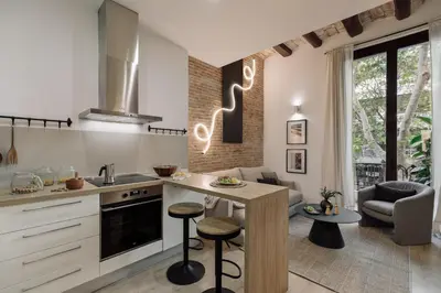a dining room and living room with a table and chairs at Chuck - 2 bedrooms and balcony in Sant Antoni in Barcelona