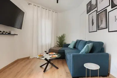 a living room with a blue couch and a table at Cozy and Modern Apartment in Poblenou 3 Bedrooms Perfect for 4 Guests in Barcelona