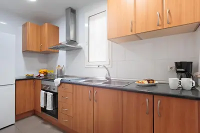 a kitchen with wooden cabinets and a sink at Cozy and Modern Apartment in Poblenou 3 Bedrooms Perfect for 4 Guests in Barcelona