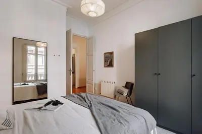a bedroom with a large bed with a wooden headboard at Vico - 4 bedrooms and office in Eixample Dreta in Barcelona