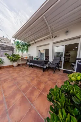 an outdoor patio with awning and tables and chairs at Terrace & BEACH apartment in Calella