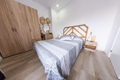 a bedroom with a bed and a wooden floor at Terrace & BEACH apartment in Calella