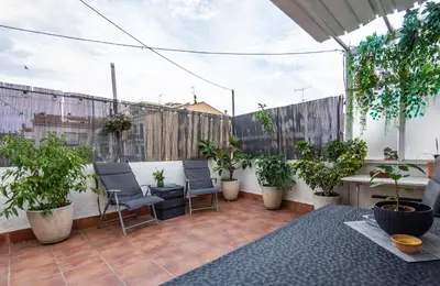 a patio with chairs and potted plants on a balcony at Terrace & BEACH apartment in Calella