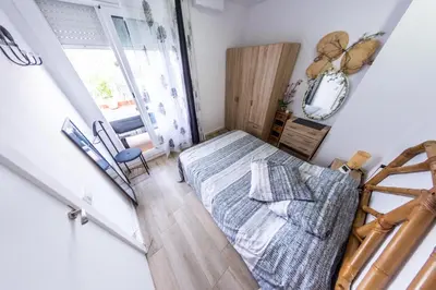 a small bedroom with a bed and a window at Terrace & BEACH apartment in Calella