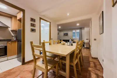 a kitchen and dining room with a wooden table and chairs at Casa en Barcelona in Barcelona