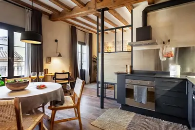 a kitchen and dining room with a table and a dining room at Atuh - Studio and terrace in El Born in Barcelona