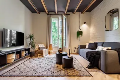 a living room with a couch and a tv at Baharya - 2 bedrooms in Eixample Dreta in Barcelona