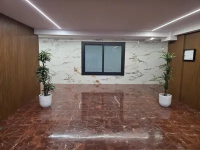 an empty lobby with potted plants and glass doors at Acogedor Apartamento Centro , Cerca de Plaza España y Barcelona in Hospitalet de Llobregat