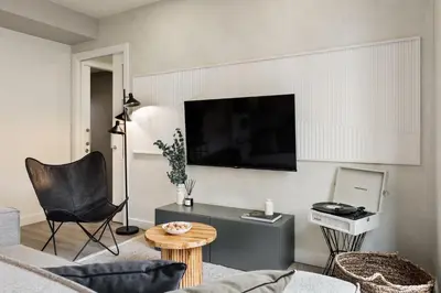 a living room with a couch and a tv at Falco - 2 bedrooms with shared pool in Les Corts in Barcelona