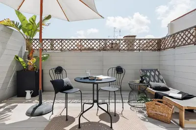 a patio with a couch and a table on a balcony at Aoraki - Penthouse and terraces in Eixample Dreta in Barcelona