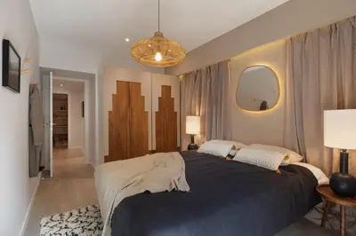 a bedroom with a bed with two lamps and a mirror at Talat - 3 bedrooms in Eixample Esquerra in Barcelona