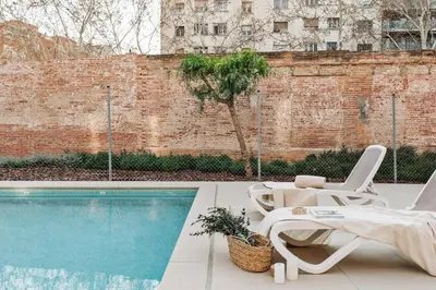 a pool with two lounge chairs next to a swimming pool at Montsia - 3 bedrooms and a terrace in Les Corts in Barcelona