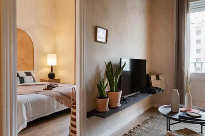 a bedroom with a bed with a tv and plants at Amourah - 2 bedrooms in Eixample Esquerra in Barcelona