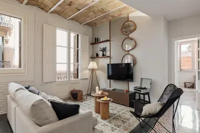 a living room with a couch and chairs and a tv at Salar - 2 bedrooms in Gràcia in Barcelona
