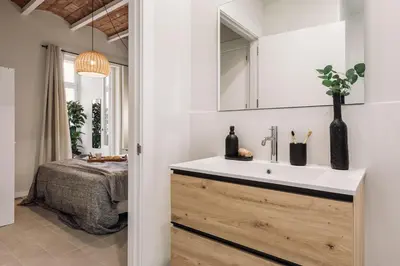 a hallway with a black stool and a mirror at Pacaya - 2 bedrooms, office and balcony in Eixample Dreta in Barcelona