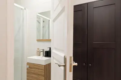 a bathroom with a sink and a mirror and a door at Adile - 4 bedrooms and balcony in El Putxet in Barcelona