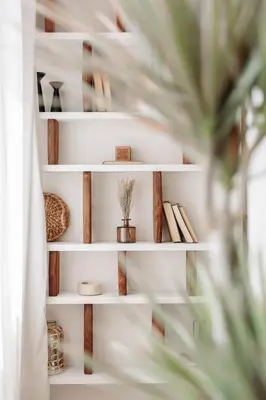 a white book shelf with books and a plant at Stabia - 2 bedrooms in Sant Gervasi in Barcelona