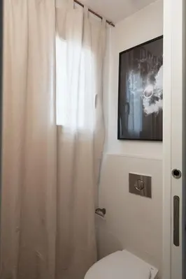 a bathroom with a white shower curtain and a toilet at Kalahari - 2 bedrooms and terrace in Gràcia in Barcelona