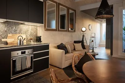 a book and a bowl of fruit on a wooden chair at Kalahari - 2 bedrooms and terrace in Gràcia in Barcelona