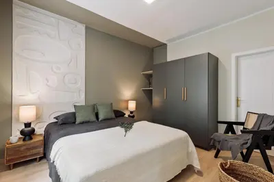 a bedroom with a large bed and a painting on the wall at Izabal - 3 bedrooms and office in Eixample Esquerra in Barcelona