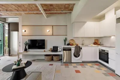 a kitchen and living room with a couch and a table at Uyuni - 2 bedrooms and balcony in Eixample Dreta in Barcelona