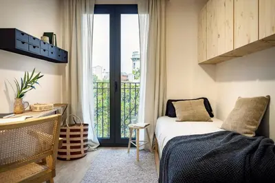a bedroom with a bed and a large window at Tokashi - 2 bedrooms and balcony in Eixample Dreta in Barcelona