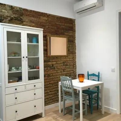 a dining room with a white cabinet and a table at Apartamento CAMP NOU in Hospitalet de Llobregat