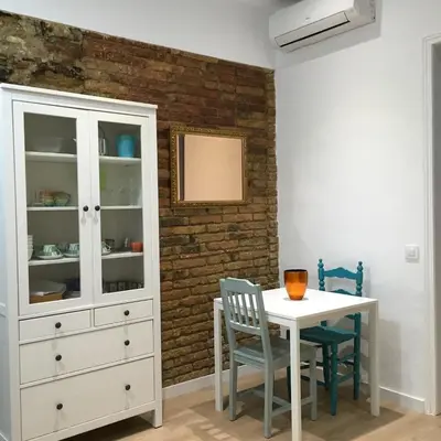a dining room with a white cabinet and a table at Apartamento CAMP NOU in Hospitalet de Llobregat