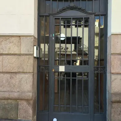a black door of a building with bars on it at Apartamento CAMP NOU in Hospitalet de Llobregat