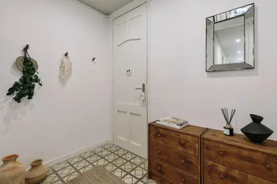 a hallway with a black cabinet and a window at Oltre - 3 bedrooms in Eixample Esquerra in Barcelona