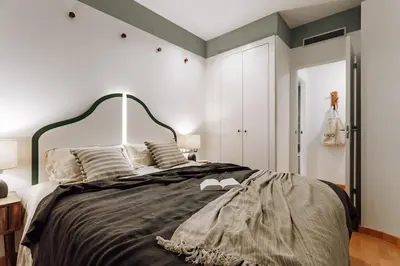 a kitchen with a stove top oven next to a living room at Huelma - 1 bedroom and terrace in Eixample Dreta in Barcelona