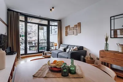 a dining room with a table and a couch at Huelma - 1 bedroom and terrace in Eixample Dreta in Barcelona
