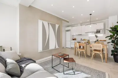 a white kitchen with white appliances and a table at Ona - 2 bedrooms in Sant Gervasi in Barcelona