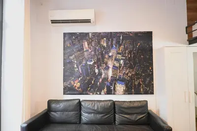 a couch in a living room with a painting on the wall at Homenfun Barcelona Ciutat Vella in Barcelona