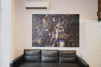 a couch in a living room with a painting on the wall at Homenfun Barcelona Ciutat Vella in Barcelona