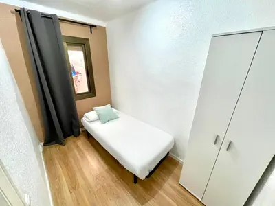 a small room with a bed and a cabinet at Gran apartamento nuevo de 3 Hab, a 1 minuto del metro HBB in Hospitalet de Llobregat