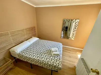 a small room with a bed and a mirror at Gran apartamento nuevo de 3 Hab, a 1 minuto del metro HBB in Hospitalet de Llobregat