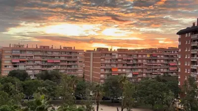 a sunset in a city with tall buildings at Alojamiento,Les corts in Barcelona