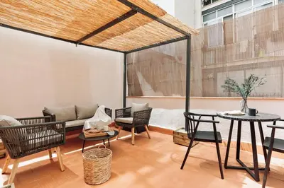a living room with a couch and a table and chairs at Acconci - Studio and terrace in Eixample Esquerra in Barcelona