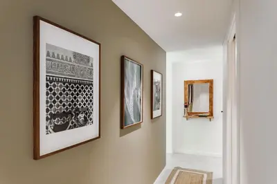 a hallway with three framed pictures on the wall at Aldeire - 2 bedrooms, office in Eixample Esquerra in Barcelona