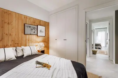 a bedroom with a large bed with a wooden wall at Aldeire - 2 bedrooms, office in Eixample Esquerra in Barcelona
