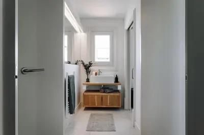 a bathroom with a sink and a mirror and a table at Aribe - 3 bedroom and terrace in Eixample Esquerra in Barcelona