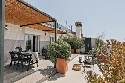 a couple of chairs and a tree on a patio at Fuji - 2 bedrooms and terrace in Eixample Esquerra in Barcelona