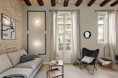 a living room with a couch and a brick wall at Espriu - 2 bedrooms and balcony in Sant Antoni in Barcelona