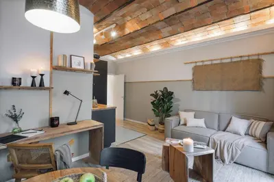 a kitchen with black cabinets and a table and a dining room at Senes - 2 bedrooms in Eixample Esquerra in Barcelona
