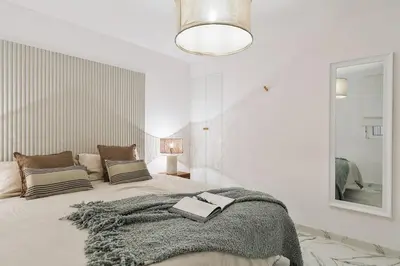 a bedroom with a bed with a blanket and a mirror at Equense - 2 bedrooms in Sant Gervasi in Barcelona