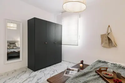 a black cabinet in a white room with a table at Equense - 2 bedrooms in Sant Gervasi in Barcelona